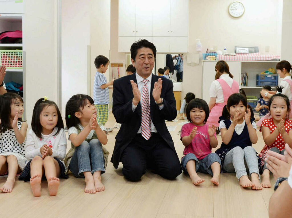 Japan's Prime Minister Shinzo Abe plays with children as he inspects a day care center in Yokohama in 2013. More than 20,000 Japanese children are on wait lists for day care.